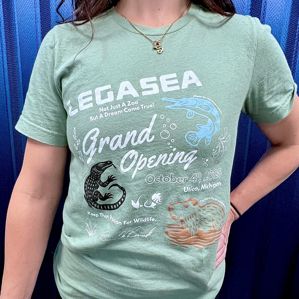 Person wearing a green t-shirt with 'LEGASEA Grand Opening' text and graphics.